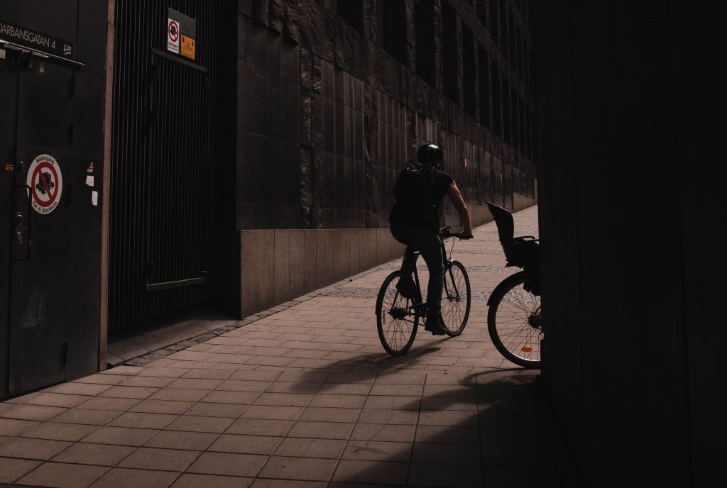 Nieoświetlony rowerzysta jadący po chodniku