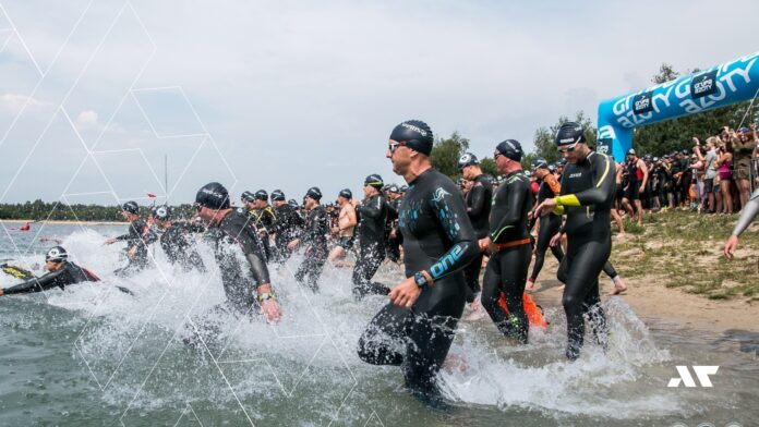Triathloniści wbiegający do wody na zawodach Grupa azoty Triathlon Radłów