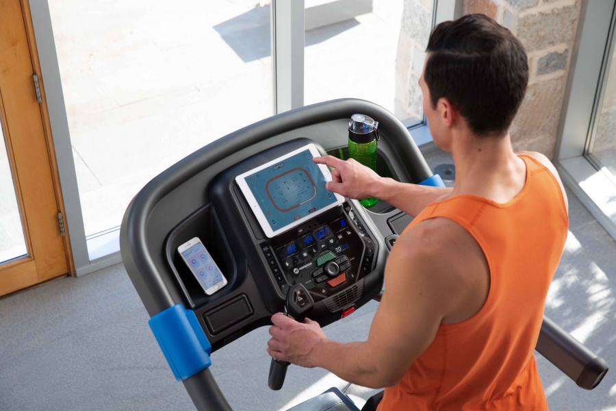 Mężczyzna trenujący na bieżni Horizon 7.0 AT w domowej siłowni