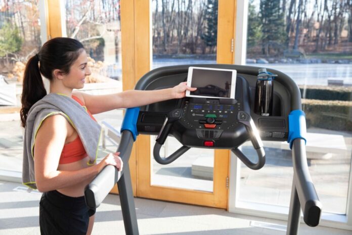 Kobieta trenująca na bieżni Horizon 7.0 AT podczas przygotowań triathlonowych