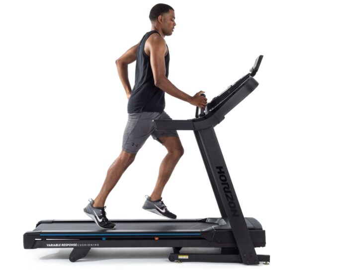 Mężczyzna trenuje na bieżni składanej Horizon 7.0 AT