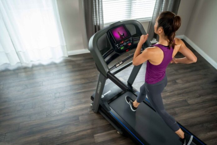 Kobieta trenująca na bieżni Horizon w domu – sprzęt sportowy po 40