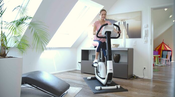 Kobieta trenująca w domu na rowerku Horizon Comfort 8.1