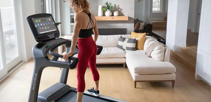 Kobieta trenująca na bieżni Matrix w domowej siłowni