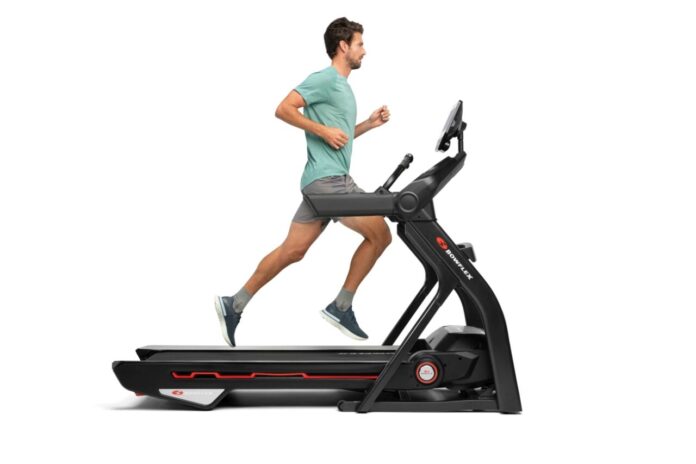 Mężczyzna trenujący na bieżni Bowflex w domowej siłowni