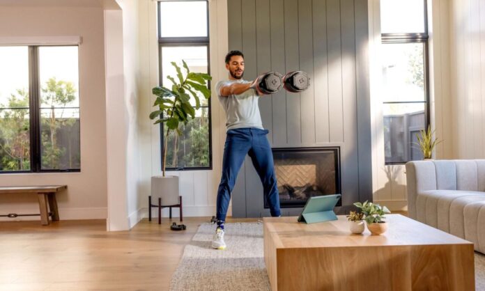 riathlonista podczas treningu zimowego w domu z hantlami