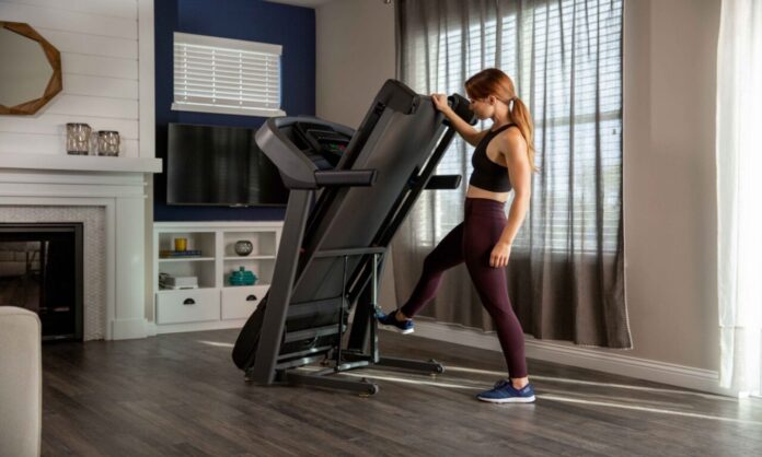 Bieżnia triathlon ustawienia – triathlonistka przygotowująca sprzęt w domu