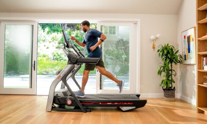 Mężczyzna biegnący na bieżni Bowflex podczas treningu w domu