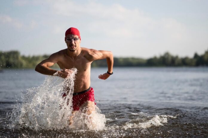 Triathlonista wychodzi z wody po treningu pływackim – tapering i przygotowanie do startu