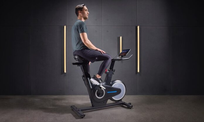 Mężczyzna trenuje na rowerze stacjonarnym Horizon – orbitrek vs rower stacjonarny