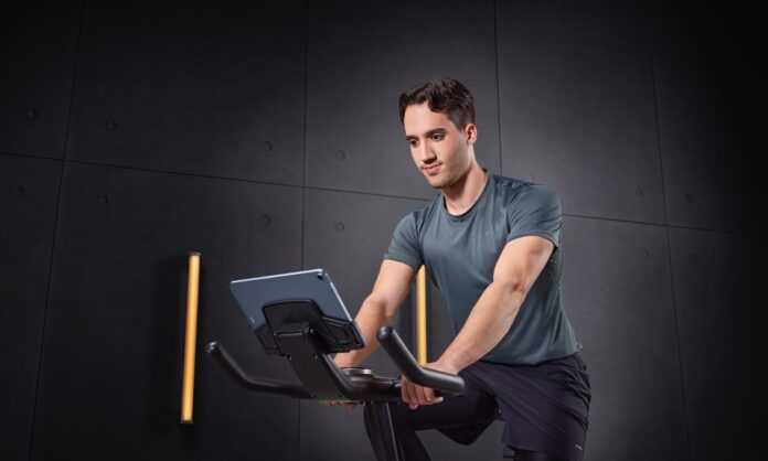 Mężczyzna trenuje na rowerze stacjonarnym – sprzęt po kontuzji