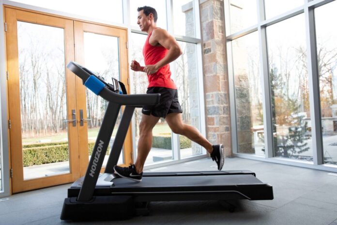 Bieżnia Horizon 7.0AT – mężczyzna biegnący w domowej siłowni