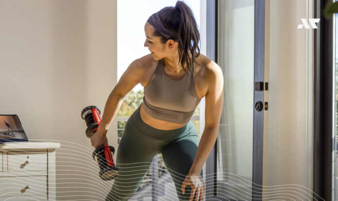 Kobieta ćwiczy w domu z hantlami Bowflex