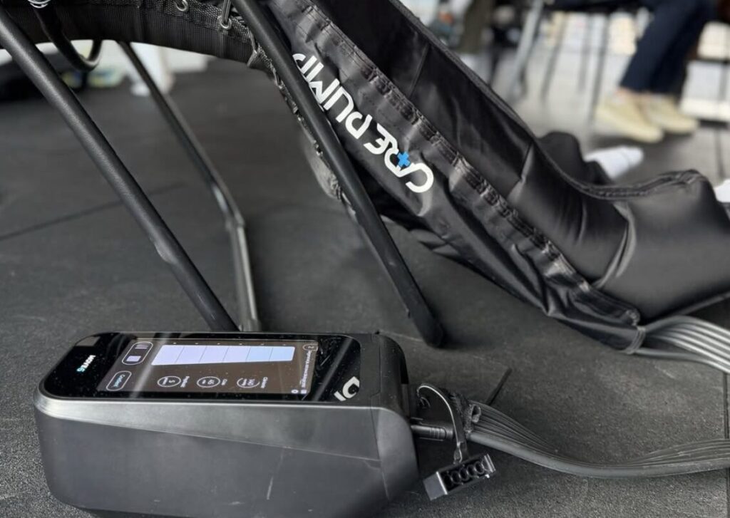 Presoterapia – urządzenie do drenażu limfatycznego CarePump z mankietami uciskowymi na nogach podczas regeneracji po treningu.
