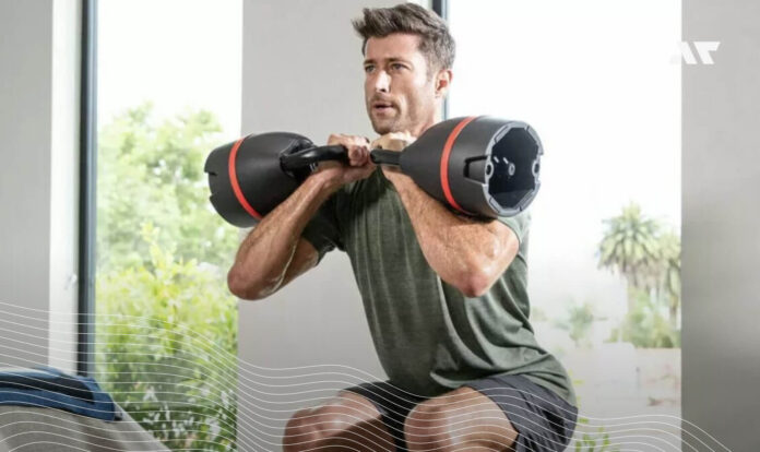 Mężczyzna ćwiczy z regulowanymi hantlami Bowflex