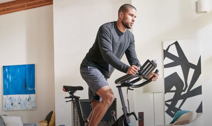 Sportowiec trenujący na rowerze stacjonarnym Schwinn w domowej siłowni – Schwinn promocje