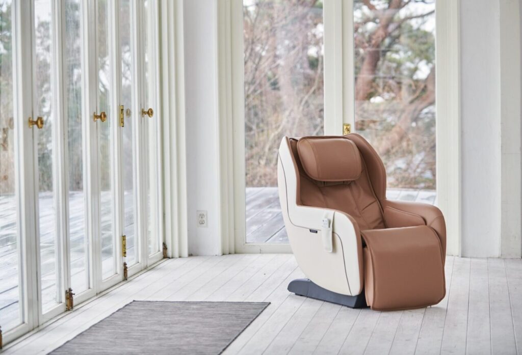 Fotel masujący ustawiony w jasnym domowym wnętrzu, energooszczędne urządzenie do codziennej regeneracji
