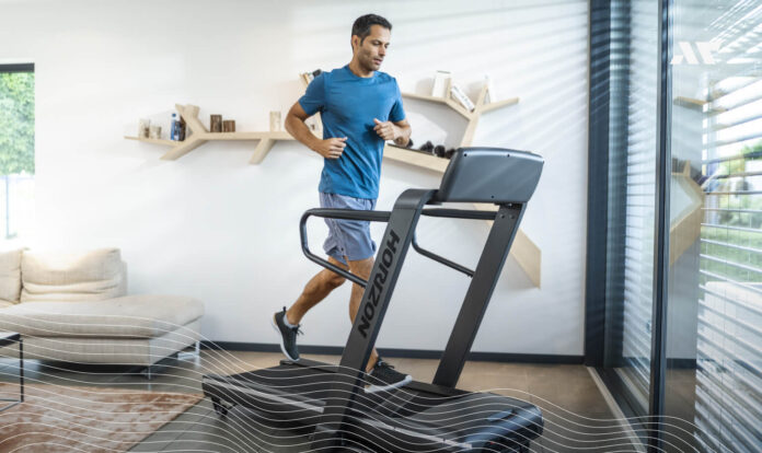 Mężczyzna podczas biegania na bieżni Horizon OMEGA Z w domowym wnętrzu – trening biegowy w domu