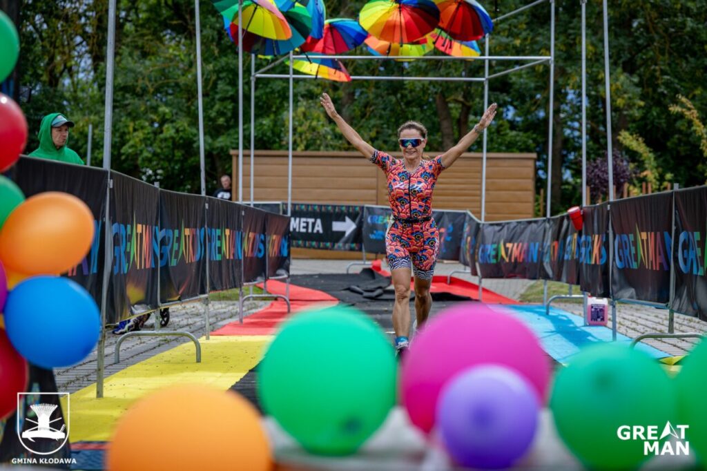 Zawodniczka przekraczająca metę Greatman Triathlon 2025 z uniesionymi rękami
