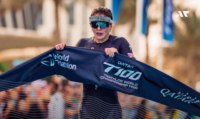 Zawodniczka na mecie finału T100 Triathlon World Championship w Katarze, trzymająca taśmę World Triathlon