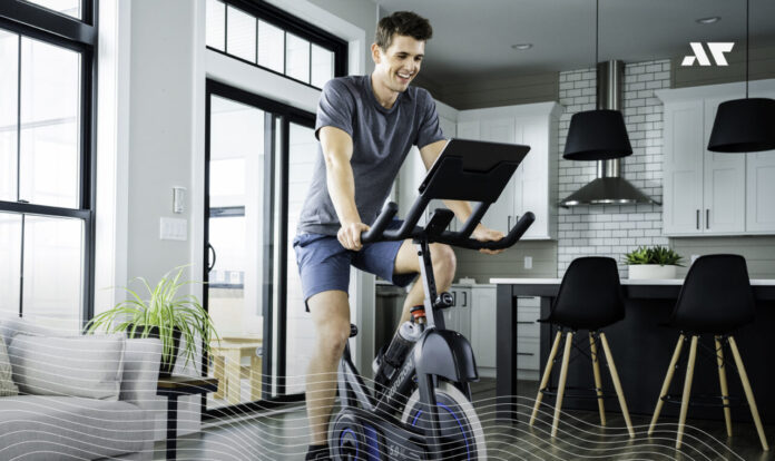 Mężczyzna trenujący na rowerze spinningowym w domu w prawidłowej pozycji