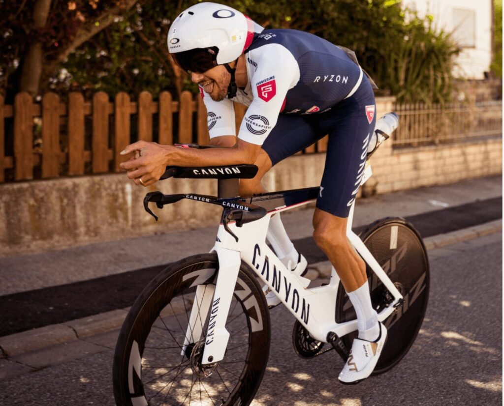 Zawodnik PRO jadący na rowerze czasowym w pozycji aerodynamicznej podczas wyścigu triathlonowego