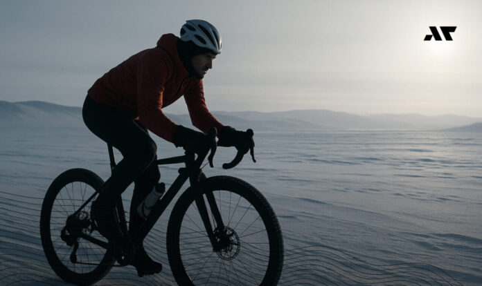 Zawodnik jadący na rowerze po lodowym terenie Antarktydy podczas ekstremalnego ultratriathlonu A100