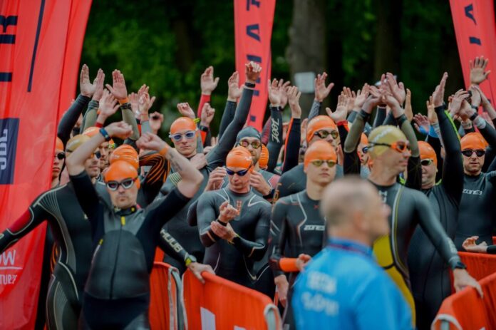 Analiza startu triathlon – zawodnicy w piankach i czepkach podczas oczekiwania na start etapu pływackiego