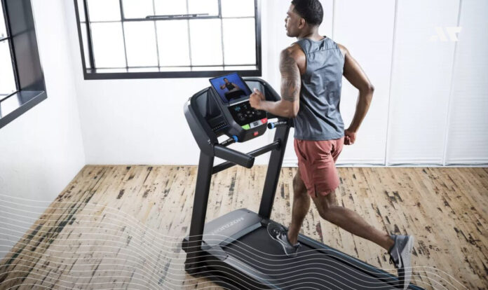 Mężczyzna podczas treningu biegowego na bieżni Horizon w domowej siłowni