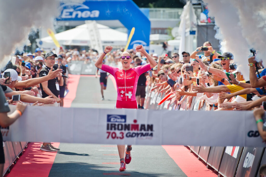 Zawodniczka przekraczająca linię mety IRONMAN 70.3 Gdynia, witana przez kibiców podczas zawodów triathlonowych w Polsce