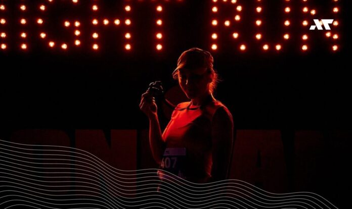 Zawodniczka z medalem podczas Night Run IRONMAN Poland nocą