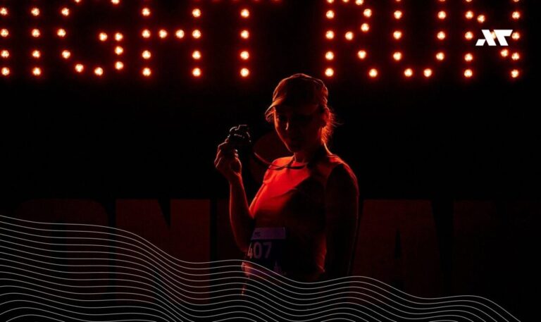 Zawodniczka z medalem podczas Night Run IRONMAN Poland nocą