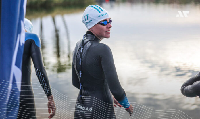 Triathlonistka w piance triathlonowej przygotowująca się do startu pływackiego w wodach otwartych