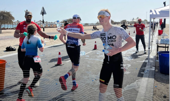 Pieter Heemeryck podający wodę zawodnikom age-group na punkcie odżywczym podczas Challenge Sir Bani Yas