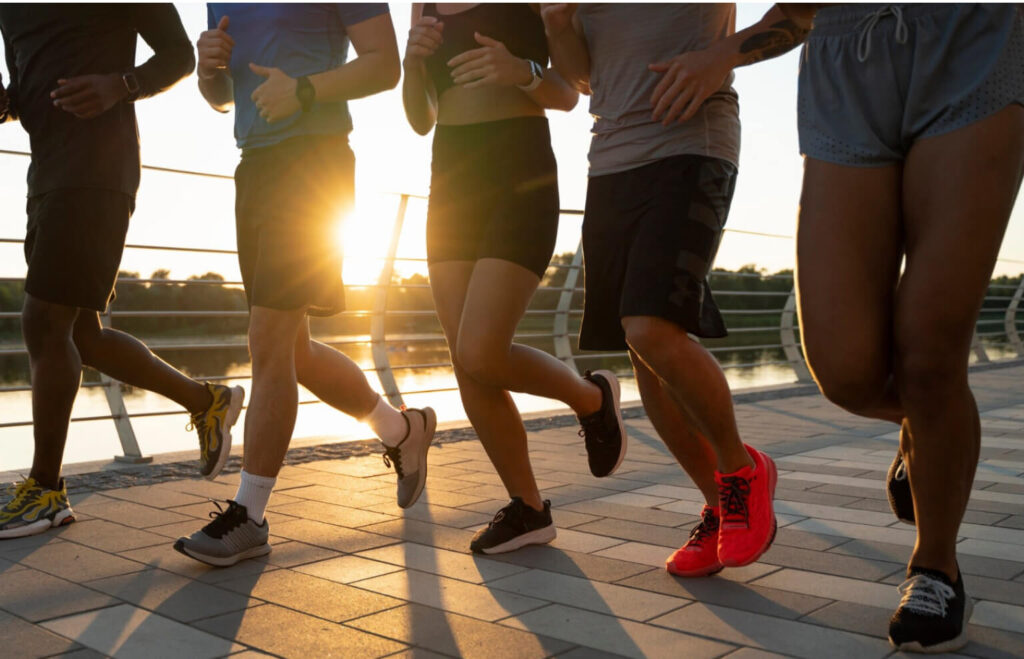 Zawodnicy podczas wspólnego treningu biegowego o zachodzie słońca – przygotowanie mentalne i koncentracja przed zawodami triathlonowymi.
