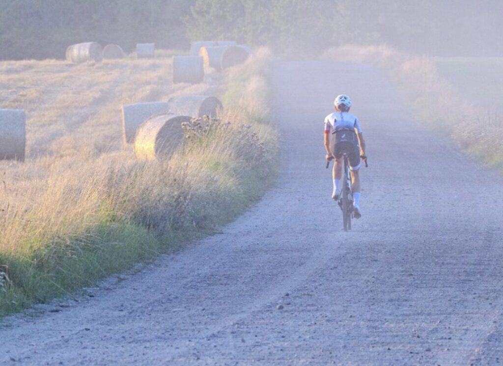 Triathlonista jadący na rowerze gravelowym podczas startu przed sezonem triathlonowym