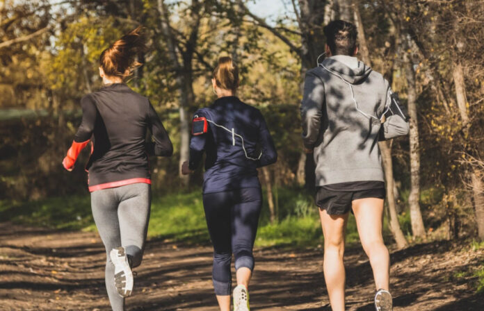 Zawodnicy podczas spokojnego treningu biegowego w terenie – kontrola objętości i zarządzanie obciążeniem w triathlonie.