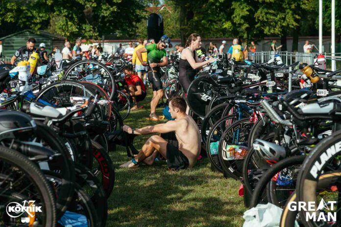 Zawodnicy przygotowujący sprzęt w strefie zmian podczas zawodów triathlonowych GREATMAN