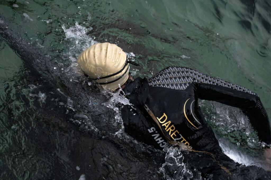 Pływak w piance triathlonowej Dare2Tri podczas treningu pływania w open water. 
