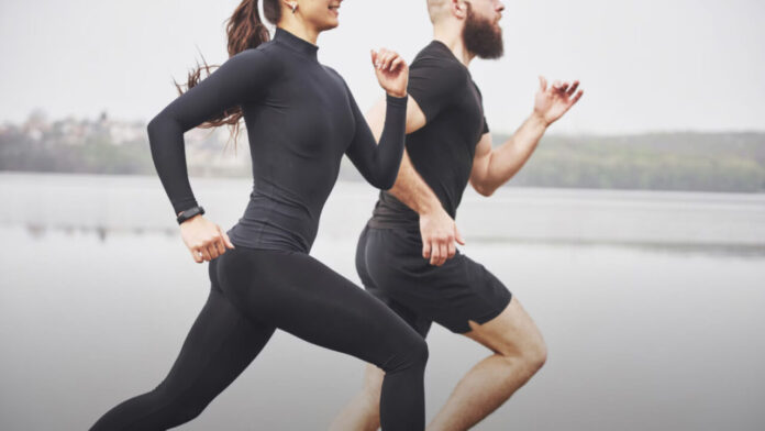 Kobieta i mężczyzna biegnący w tempie kontrolnym podczas lekkiego treningu w okresie taperingu przed startem w triathlonie.