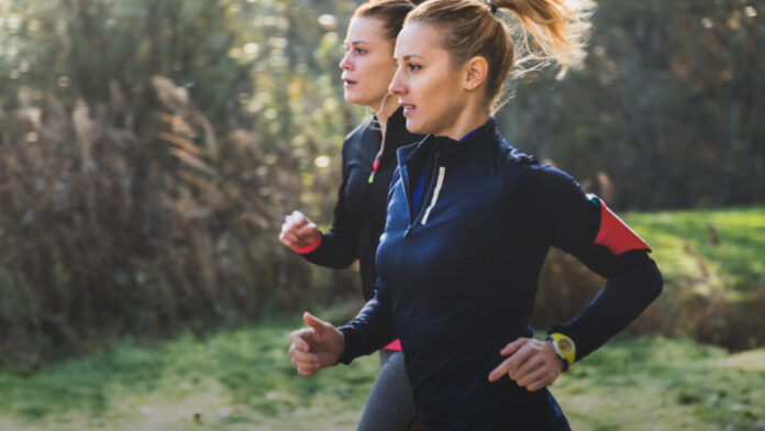 Dwie zawodniczki podczas treningu biegowego w lesie, przygotowanie biegowe do triathlonu.