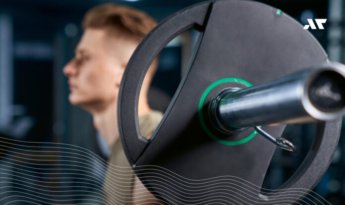 Triathlonista wykonujący ćwiczenie ze sztangą podczas treningu siłowego w przygotowaniu do sezonu triathlonowego