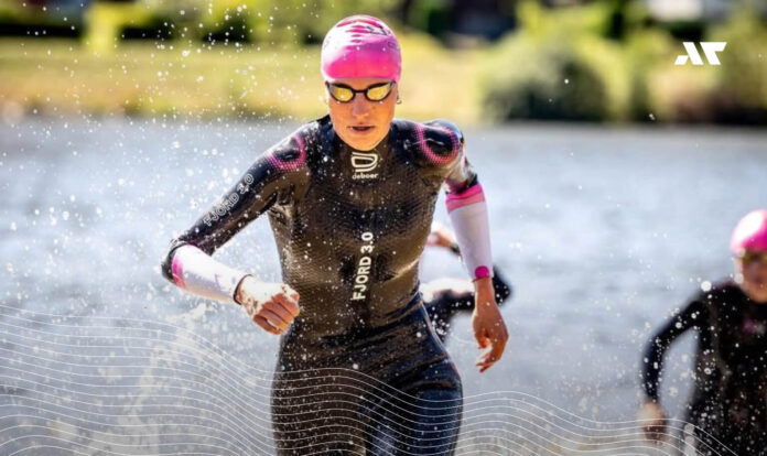 Triathlonistka w piance deboer wychodząca z wody podczas zawodów triathlonowych.